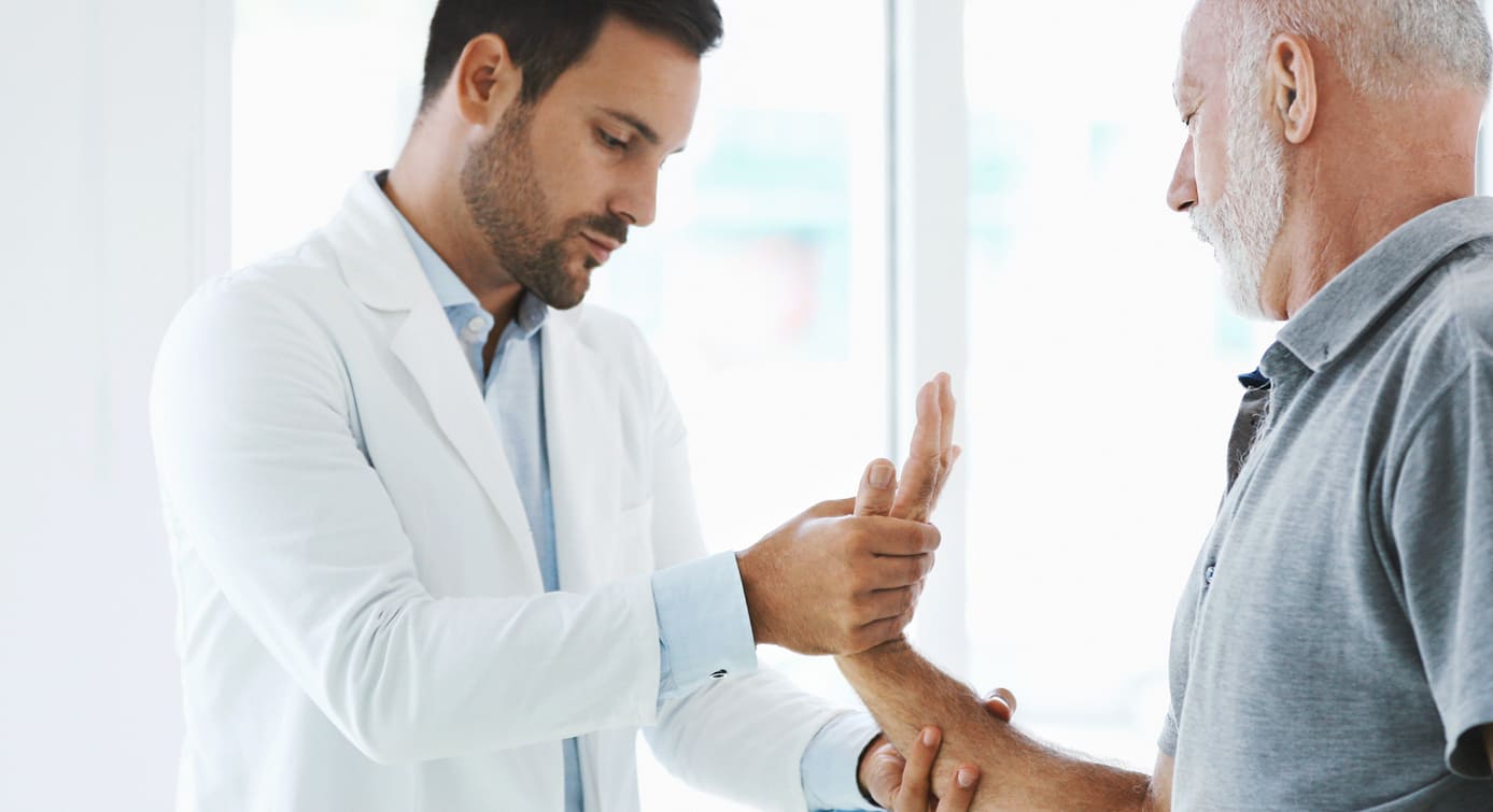 Arzt prüft das Handgelenk eines Rheuma-Patienten auf Schmerzen.